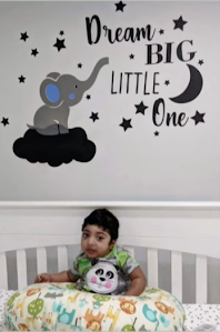 raghav in crib and sign on wall says dream big little one